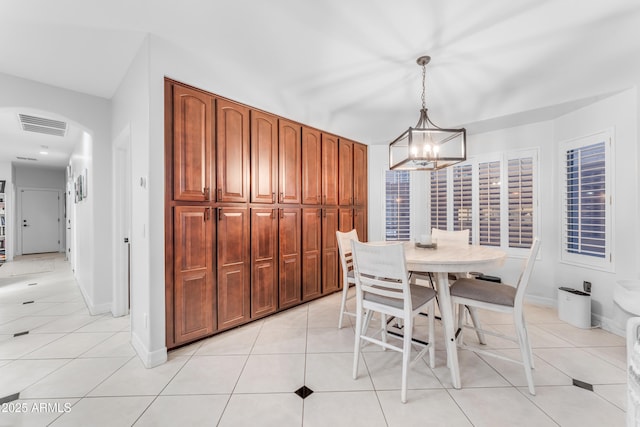 dining area with light tile patterned flooring and an inviting chandelier