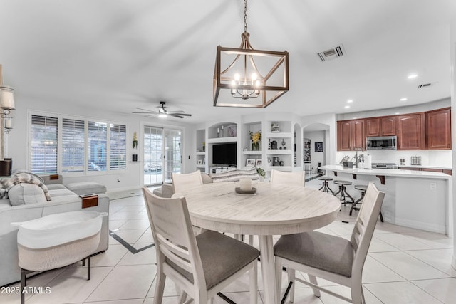 tiled dining area with ceiling fan with notable chandelier and built in features