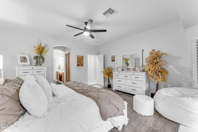 bedroom with ceiling fan, wood-type flooring, and connected bathroom