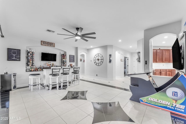 tiled living room with indoor bar and ceiling fan