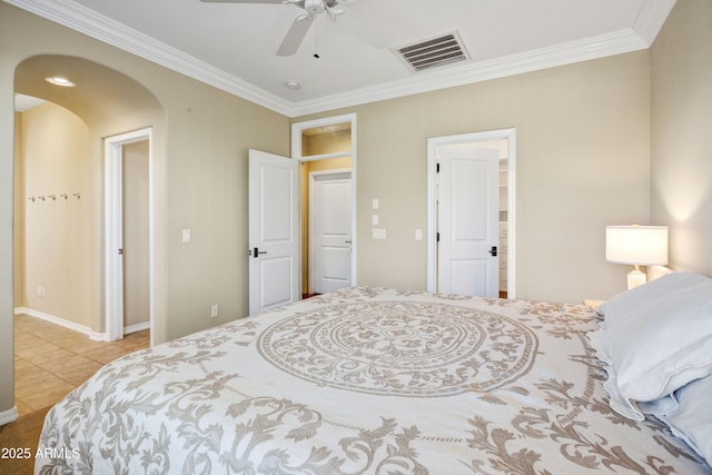 tiled bedroom featuring ornamental molding, arched walkways, a ceiling fan, and baseboards
