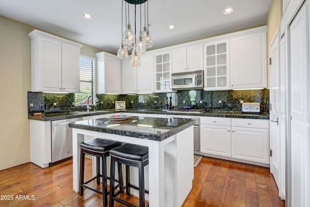 kitchen featuring appliances with stainless steel finishes, a sink, white cabinetry, and recessed lighting