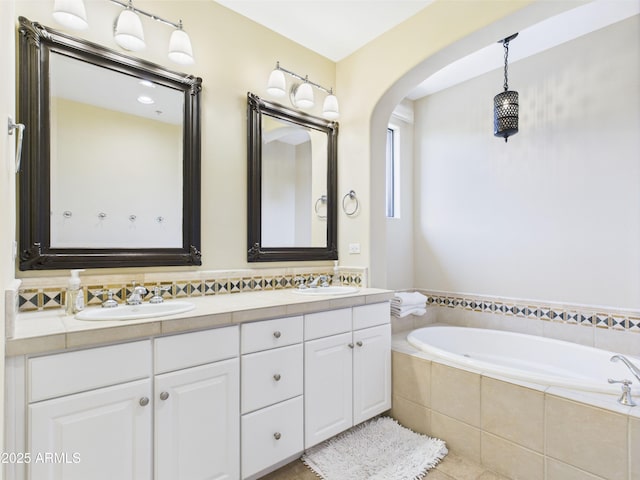 full bath featuring double vanity, a bath, and tile patterned floors
