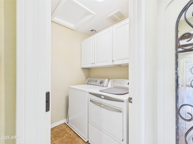 laundry area with washing machine and dryer, cabinet space, attic access, light tile patterned flooring, and baseboards