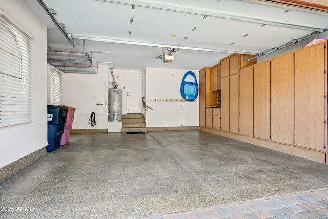 garage with water heater, a garage door opener, and baseboards