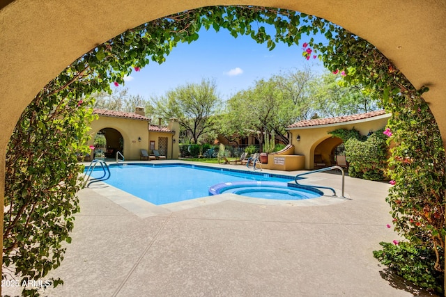 view of swimming pool with a patio and a pool with connected hot tub