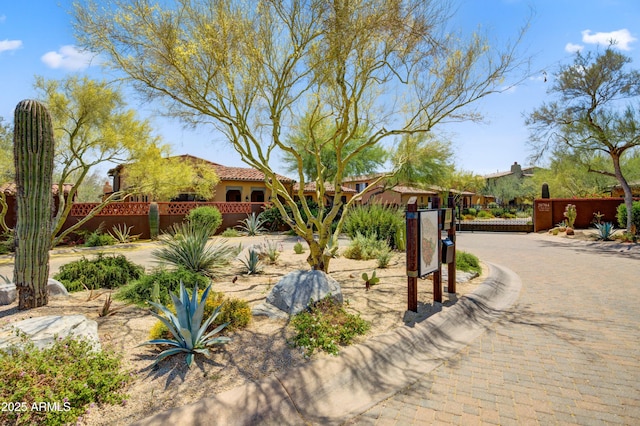 view of front of home with fence, stucco siding, a gate, and a tiled roof