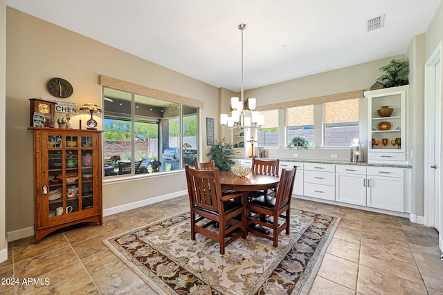 tiled dining space featuring plenty of natural light and a notable chandelier