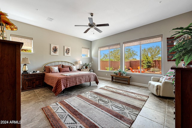 bedroom with tile floors, ceiling fan, and multiple windows