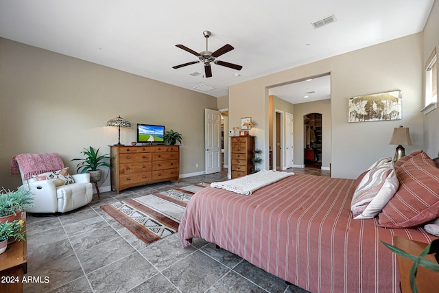 bedroom featuring tile floors, a walk in closet, a closet, and ceiling fan