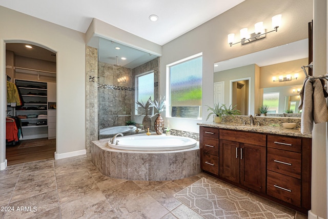 bathroom with wood-type flooring, vanity, and shower with separate bathtub