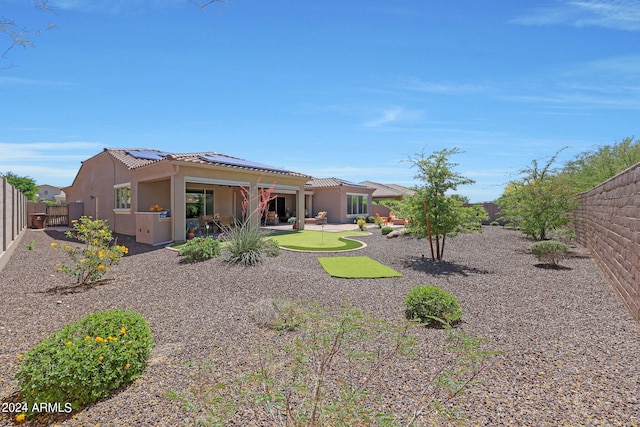 back of house with a patio and solar panels