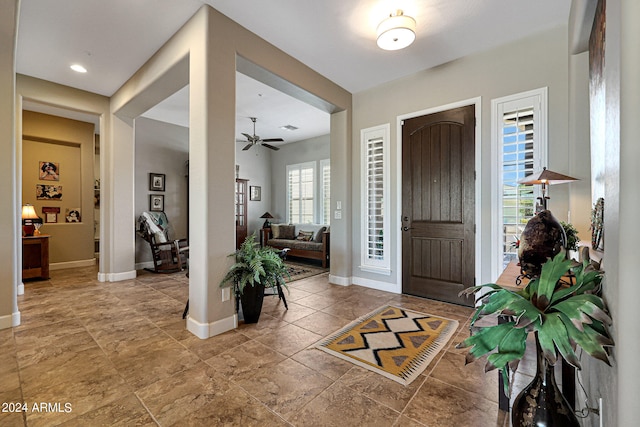 foyer with tile floors and ceiling fan