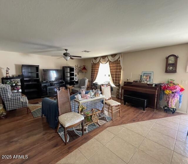 tiled living room featuring ceiling fan