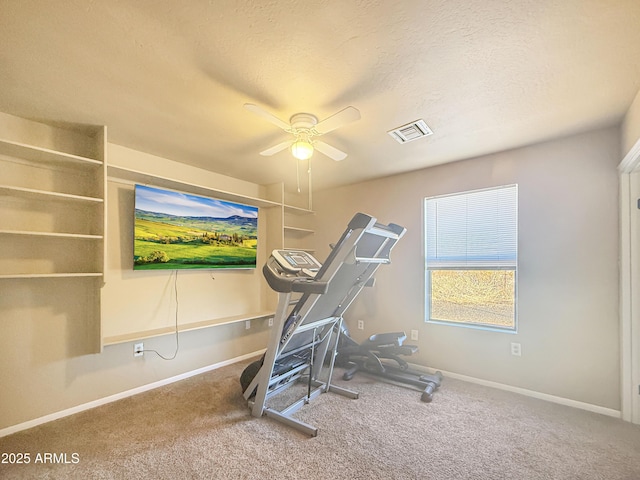 exercise room with ceiling fan, a textured ceiling, and carpet flooring