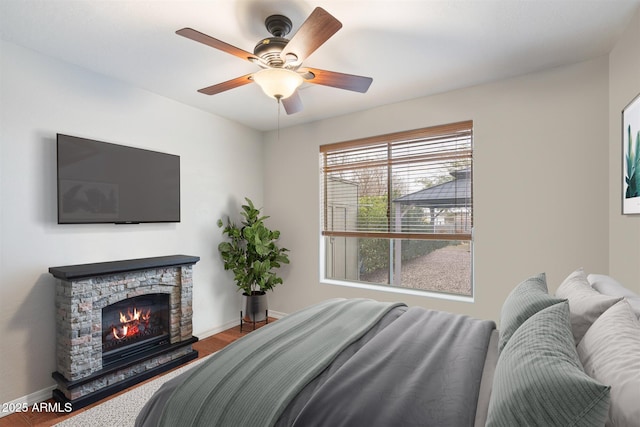 19428 E Hunt Hwy, Queen Creek, AZ 85142 - bedroom with a ceiling fan, baseboards, a stone fireplace, and wood finished floors