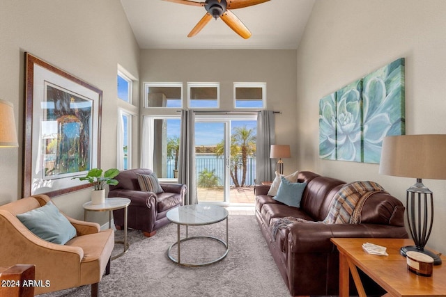 carpeted living room with high vaulted ceiling and ceiling fan