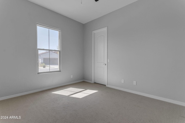 spare room with ceiling fan and light colored carpet