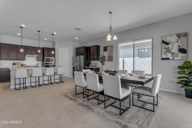 dining area with a notable chandelier and light tile patterned floors