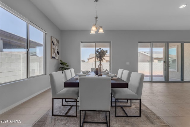 tiled dining room with plenty of natural light and a notable chandelier