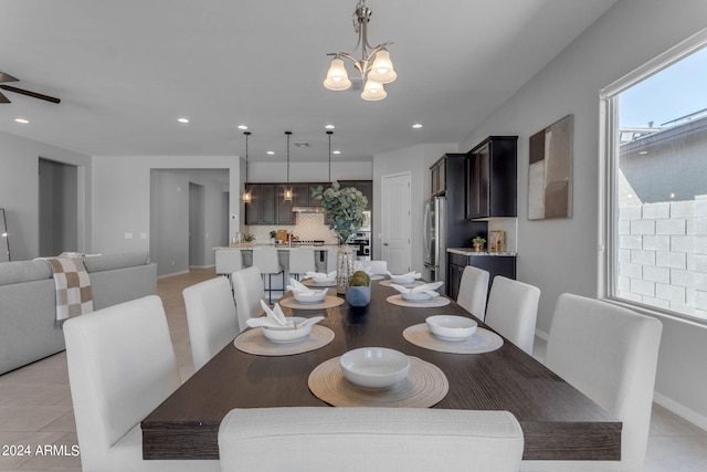 dining room featuring ceiling fan with notable chandelier and light tile patterned floors