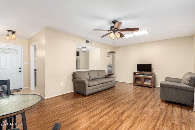 living room featuring ceiling fan and light hardwood / wood-style flooring