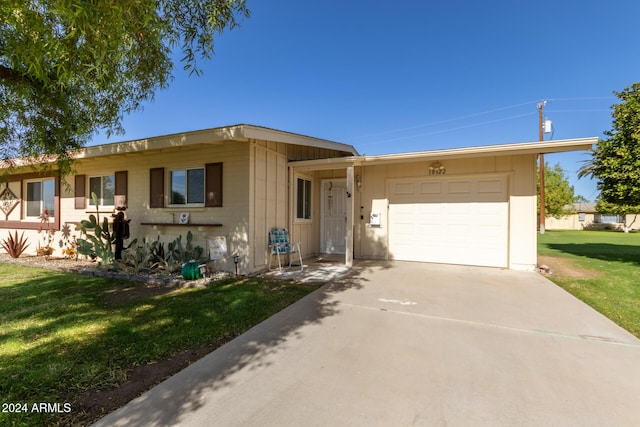 ranch-style house featuring a garage and a front lawn