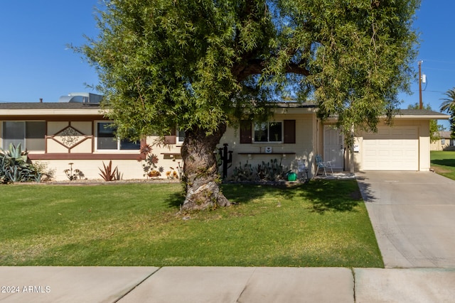 view of front of property featuring a front yard and a garage