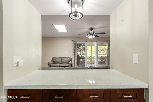 kitchen with light stone countertops and ceiling fan