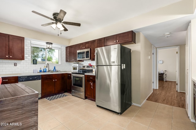 kitchen with ceiling fan, sink, tasteful backsplash, light tile patterned floors, and appliances with stainless steel finishes