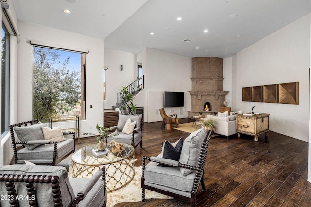 living room with a large fireplace and hardwood / wood-style flooring