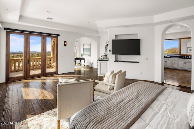 bedroom featuring access to exterior, connected bathroom, and hardwood / wood-style flooring