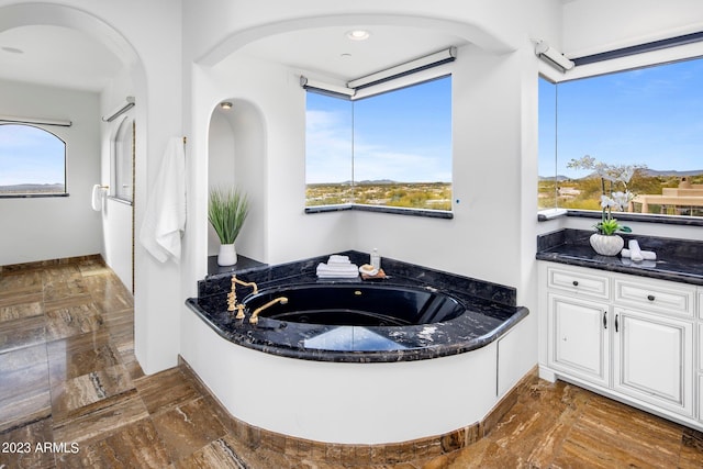 bathroom with vanity and a tub to relax in