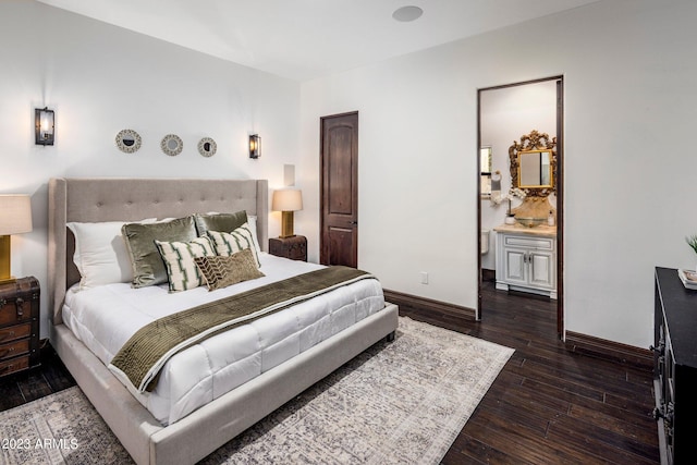 bedroom with dark wood-type flooring and connected bathroom