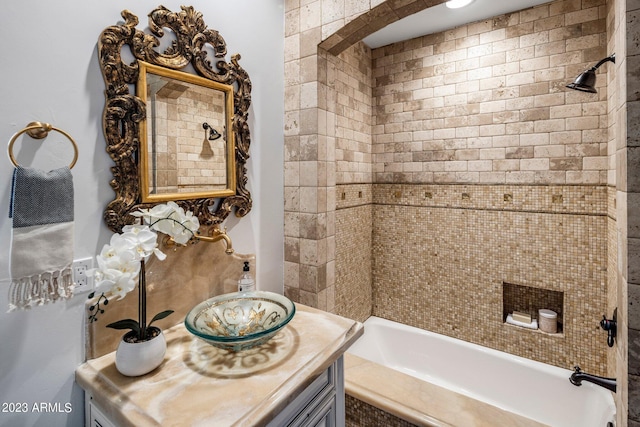 bathroom featuring vanity and tiled shower / bath