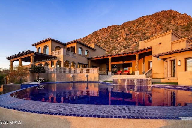 view of swimming pool with a mountain view and a pergola