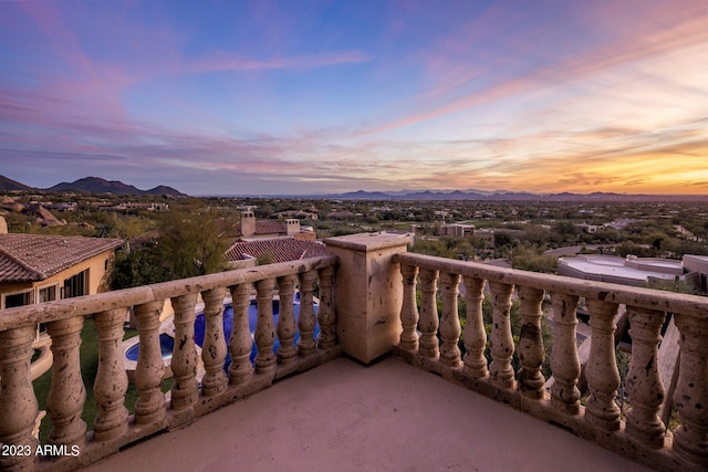 balcony at dusk featuring a mountain view