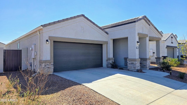 view of front facade featuring a garage, stone siding, driveway, and stucco siding