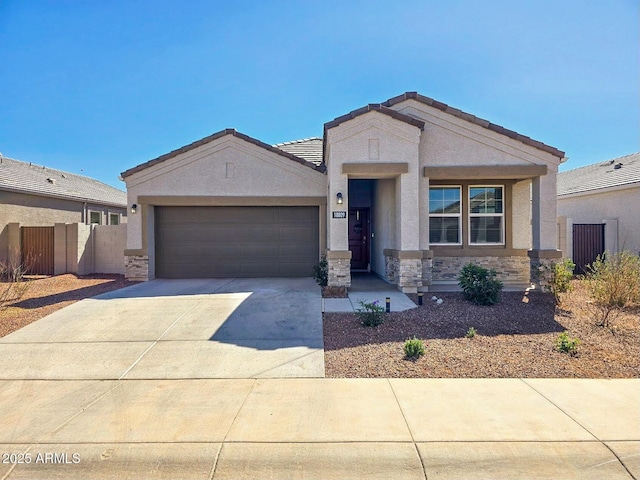 view of front of home featuring stucco siding, fence, a garage, stone siding, and driveway