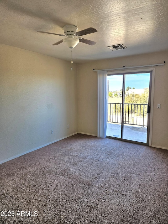 carpeted spare room featuring baseboards, visible vents, a textured ceiling, and ceiling fan