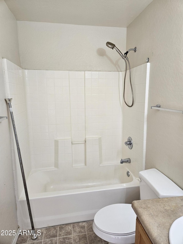 full bath featuring tile patterned floors, toilet, bathing tub / shower combination, vanity, and a textured wall