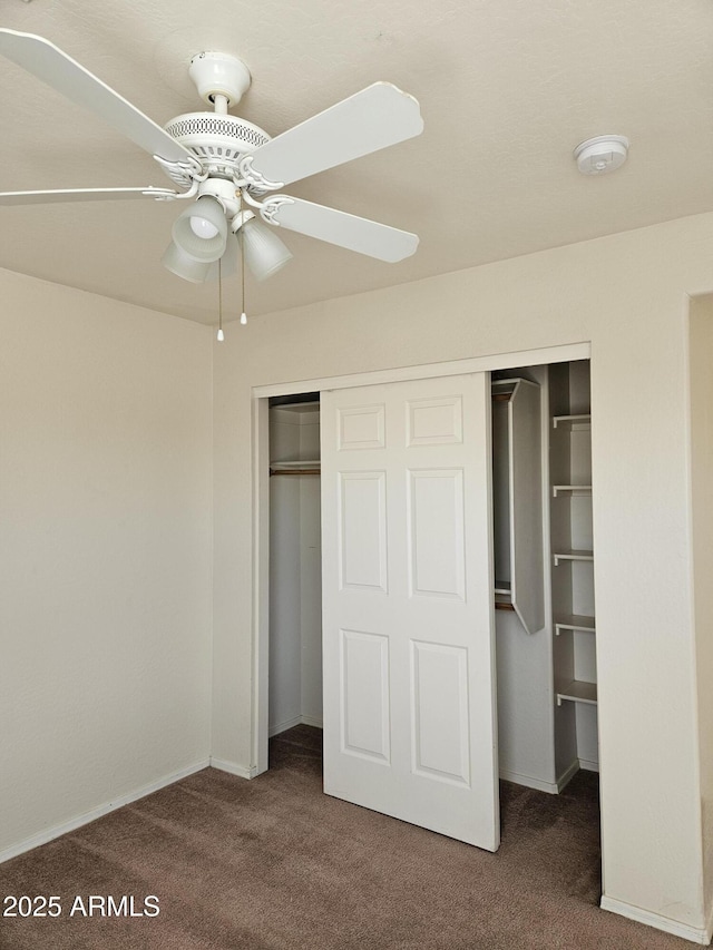 unfurnished bedroom with a closet, carpet, and a ceiling fan