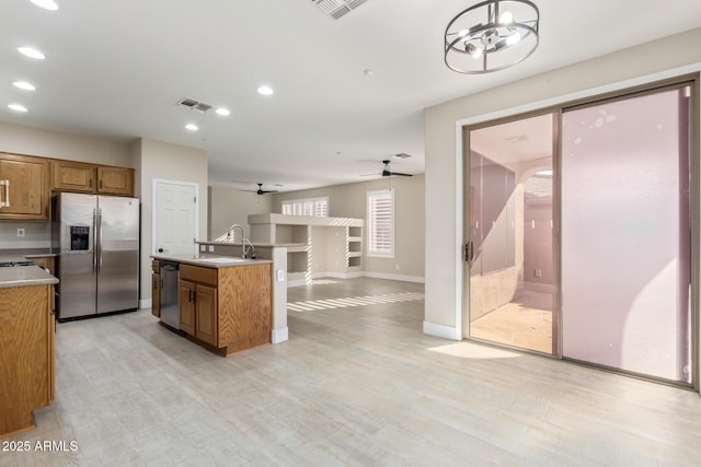 kitchen featuring stainless steel appliances, light countertops, visible vents, and brown cabinets