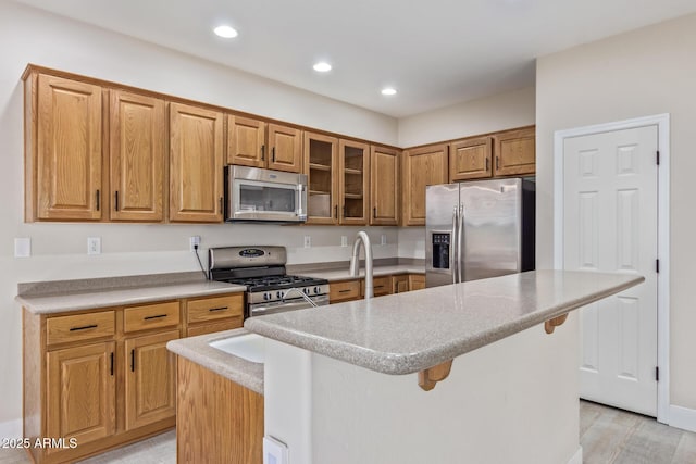 kitchen with a kitchen island, glass insert cabinets, stainless steel appliances, and recessed lighting