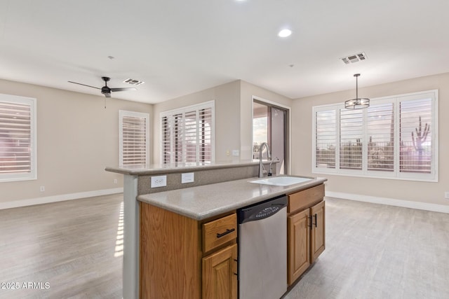 kitchen with a sink, light wood-style floors, visible vents, and dishwasher