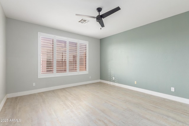 empty room featuring baseboards, ceiling fan, visible vents, and wood finished floors