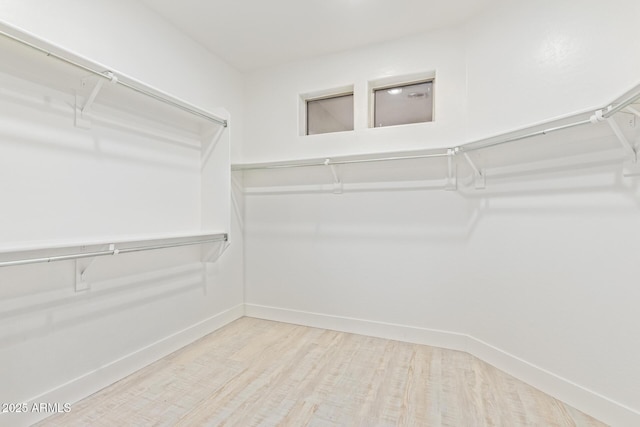 walk in closet with wood finished floors