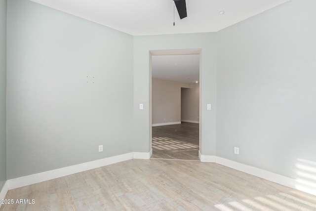 unfurnished room featuring ceiling fan, wood finished floors, and baseboards