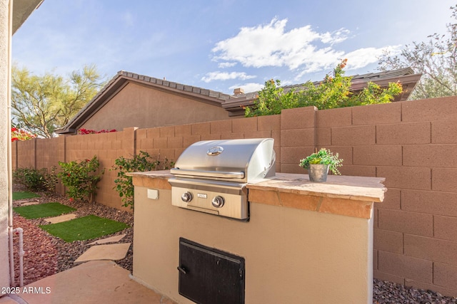 view of patio with area for grilling and a fenced backyard