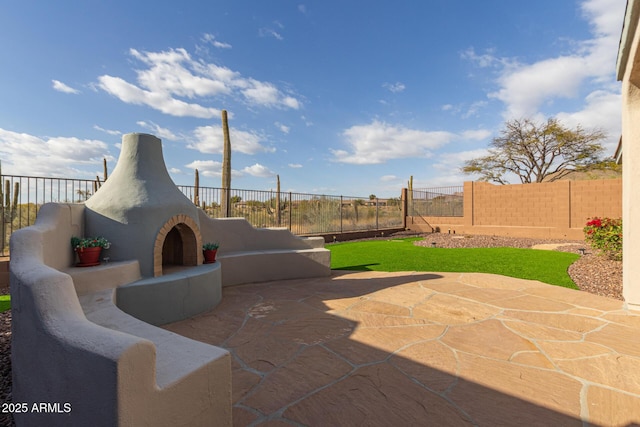 view of patio / terrace featuring a fenced backyard and exterior fireplace